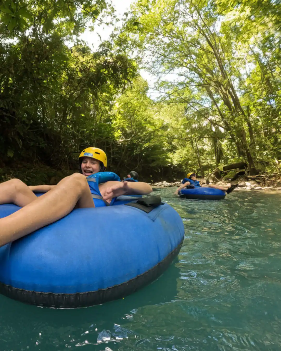 Kids tubing down the turquoise blue river on a private Rio Celeste tour
